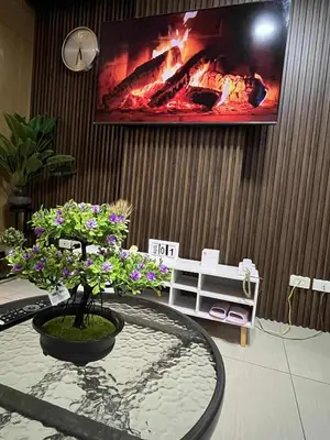 a room with a table with a fire in the wall at Staycation Near Mall of Asia in Manila