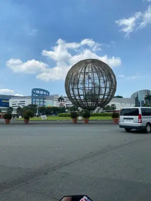 a large metal object in a parking lot with a van at Shore - Spacious Room with Balcony - 52D in Manila