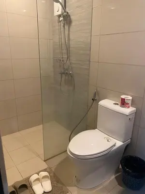 a bathroom with a toilet and a glass shower at Gentry Manor 1BR with Balcony Near Okada - 6A in Manila