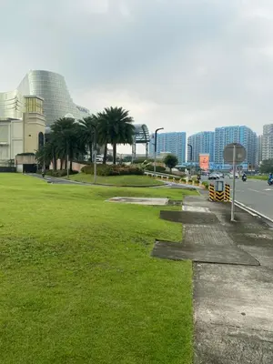 a park with palm trees on the side of a road at Gentry Manor 1BR with Balcony Near Okada - 6A in Manila