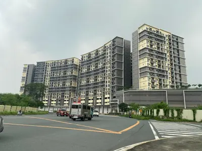 a large building with cars driving in a parking lot at Gentry Manor 1BR with Balcony Near Okada - 6A in Manila