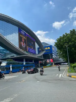 a group of motorcycles driving down a street in front of a building at Gentry Manor 1BR with Balcony Near Okada - 6A in Manila