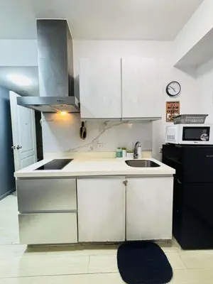a kitchen with white cabinets and a sink and a stove at Casa azure by B&M STAYCATION at Paranque in Manila