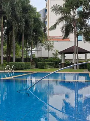 a large blue swimming pool with trees and a building at Condo Unit, 2 Beds, Wi-fi, Free Amenities in Manila
