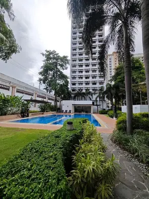a swimming pool in a city with a tall building at Condo Unit, 2 Beds, Wi-fi, Free Amenities in Manila