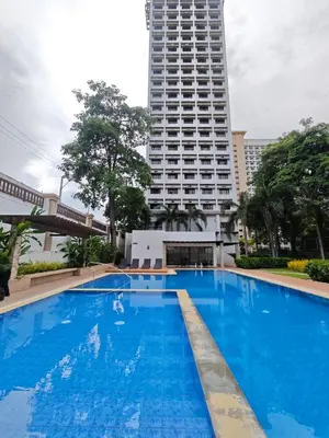 a large blue swimming pool in front of a tall building at Condo Unit, 2 Beds, Wi-fi, Free Amenities in Manila