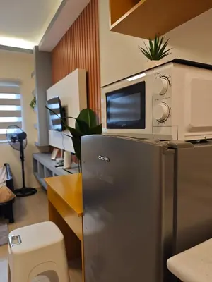a microwave sitting on top of a refrigerator at Condo Unit, 2 Beds, Wi-fi, Free Amenities in Manila