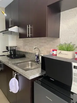 a kitchen with a sink and a microwave at Kasara Pasig Staycation in Manila