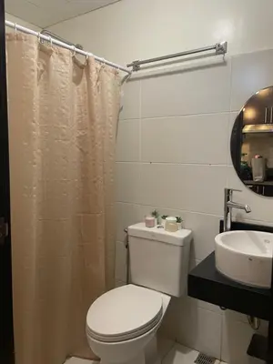 a white bathroom with a toilet and a sink at Kasara Pasig Staycation in Manila