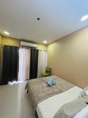 a bedroom with a large bed and a window at Milk and honey condotel in Manila