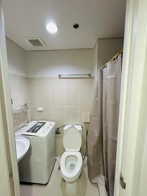 a small bathroom with a toilet and a sink at Milk and honey condotel in Manila