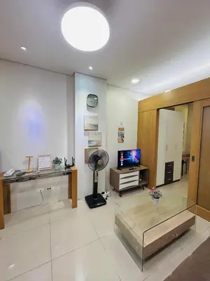 a living room with a glass table and a television at Milk and honey condotel in Manila