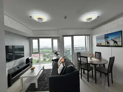 a person laying on a couch in a living room at Breeze Residences Condos in Manila