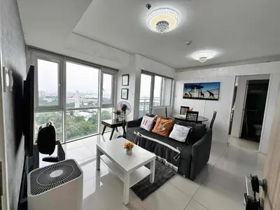 a living room with a couch and a table at Breeze Residences Condos in Manila