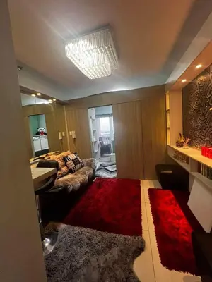 a living room with a couch and a red rug at Breeze Residences Condos in Manila