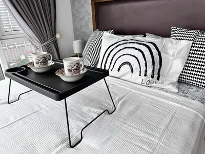 a bed with two cups and a tray on it at Breeze Residences Condos in Manila