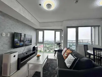 a living room with a couch and a table at Breeze Residences Condos in Manila