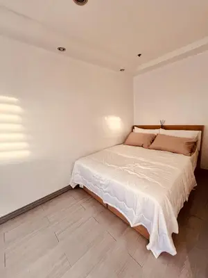 a bedroom with a large bed in a white wall at G's Bnb in Manila