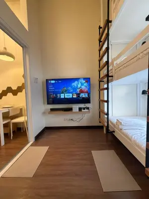 a bedroom with a bunk bed and a flat screen tv at The Camden Place Family Group Apartment Condo Unit in Manila