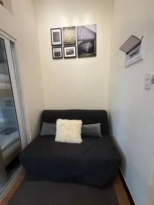 a black couch with a white pillow in a room at The Camden Place Family Group Apartment Condo Unit in Manila