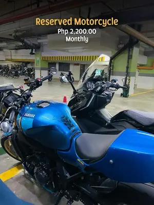 a blue motorcycle parked in a parking lot at 2 Bedroom Unit with Queen-sized Beds near NAIA T3 in Manila