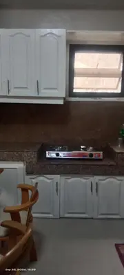 a kitchen with a stove and a window on a counter at Victoria's capsule bed in Manila