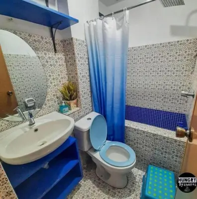 a bathroom with a blue toilet and a sink at Affordable Bed And Breakfast along Ortigas Ave in Cupang