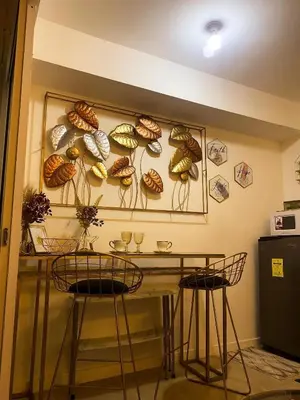 a room with a table and two chairs and a wall with fossils at Azure Luxe Suites in Azure Bicutan Near NAIA and MOA in Manila