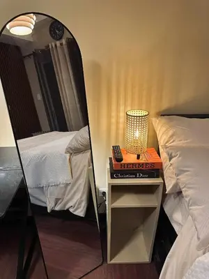 a mirror reflecting a room with two beds and a table with a lamp at La Verti Residences Pasay City in Manila