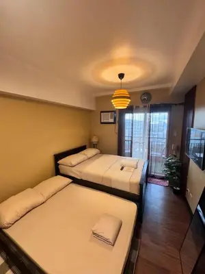 a room with two beds and a tv and a room at La Verti Residences Pasay City in Manila