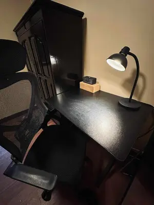 a black desk with a lamp and a chair at La Verti Residences Pasay City in Manila
