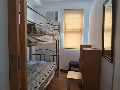 a bedroom with two bunk beds in a room at The Dwelling Place at Metrotowne Las Pinas in Manila