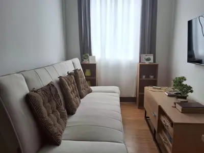 a living room with a white couch with pillows at The Dwelling Place at Metrotowne Las Pinas in Manila