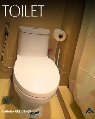 a white toilet in a bathroom with a toilet paper at Cabana Residence at Shore 3 - MOA Complex in Manila