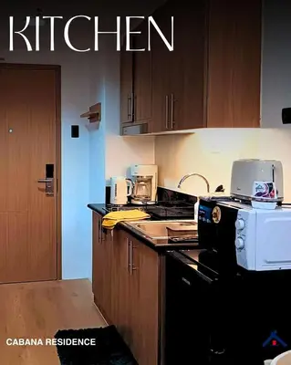 a kitchen with a stove top oven next to a counter at Cabana Residence at Shore 3 - MOA Complex in Manila