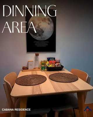 a wooden table with chairs and a poster of the moon at Cabana Residence at Shore 3 - MOA Complex in Manila