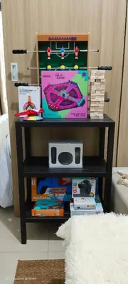 a shelf with books and a table with a clock on it at 1BR Amenity View Room at Shore Residences, Pasay Near MOA & Airport in Manila
