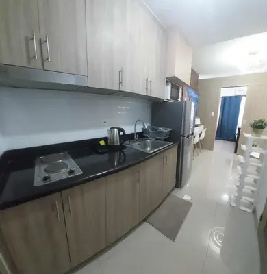 a kitchen with a sink and a refrigerator at GB Travelers Rest at Shore 2 Residences in Manila