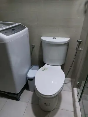 a bathroom with a white toilet and a sink at GB Travelers Rest at Shore 2 Residences in Manila