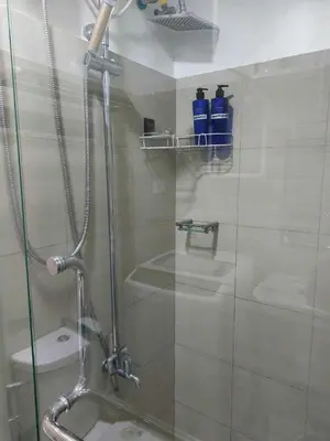 a bathroom with a shower with a glass door at GB Travelers Rest at Shore 2 Residences in Manila