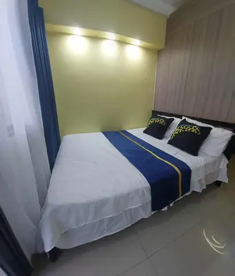 a bedroom with a large bed with two pillows at GB Travelers Rest at Shore 2 Residences in Manila