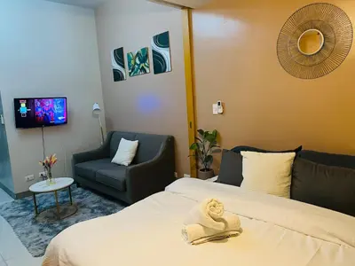 a hotel room with a bed with a towel on it at Bgc One Uptown Residences in Manila