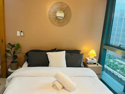 a bedroom with a bed and a window at Bgc One Uptown Residences in Manila