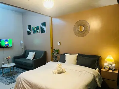 a bedroom with a bed with a stuffed animal on it at Bgc One Uptown Residences in Manila