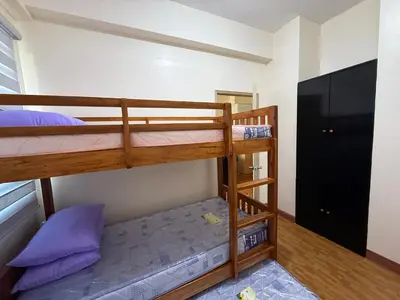 a bunk bed room with two bunk beds with purple pillows at Cypress 108 in Manggahan