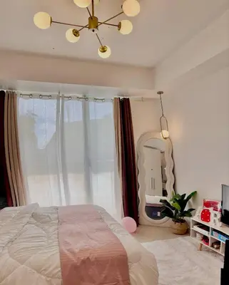 a bedroom with a large bed and a mirror at MG Labels Property in Manila