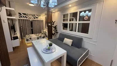 a living room with a couch and a table at Cozy 1BR Pioneer Woodland SM Light Boni Mandaluyong in Manila
