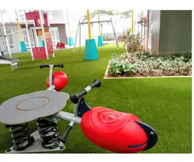 a playground with a red toy on the grass at Cozy 1BR Pioneer Woodland SM Light Boni Mandaluyong in Manila