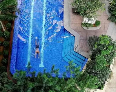 an overhead view of a swimming pool with a person in it at Cozy 1BR Pioneer Woodland SM Light Boni Mandaluyong in Manila