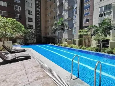 a swimming pool in front of a building at Cozy 1BR Pioneer Woodland SM Light Boni Mandaluyong in Manila